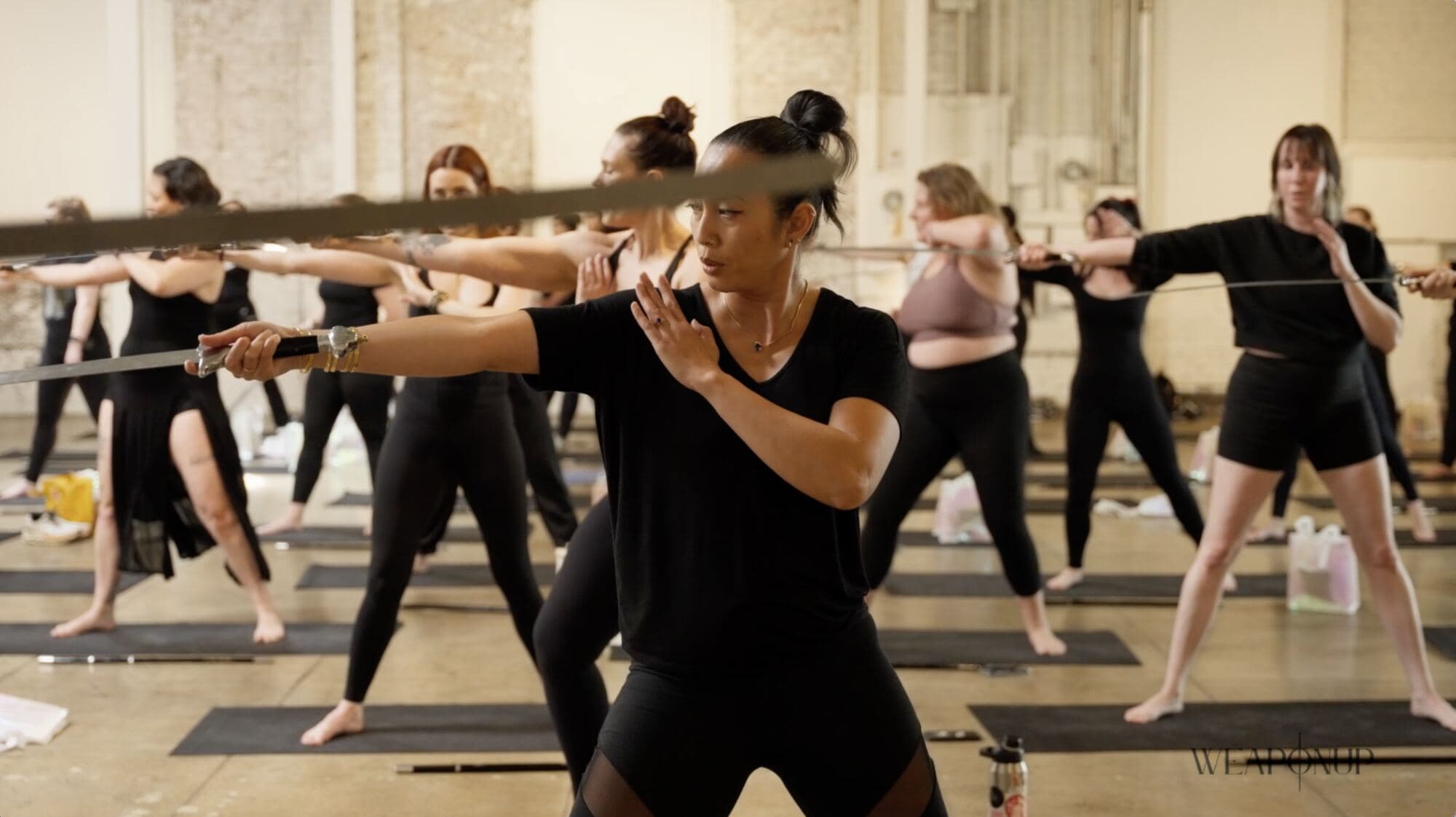 Members moving through a WeaponUp class together with their swords extended